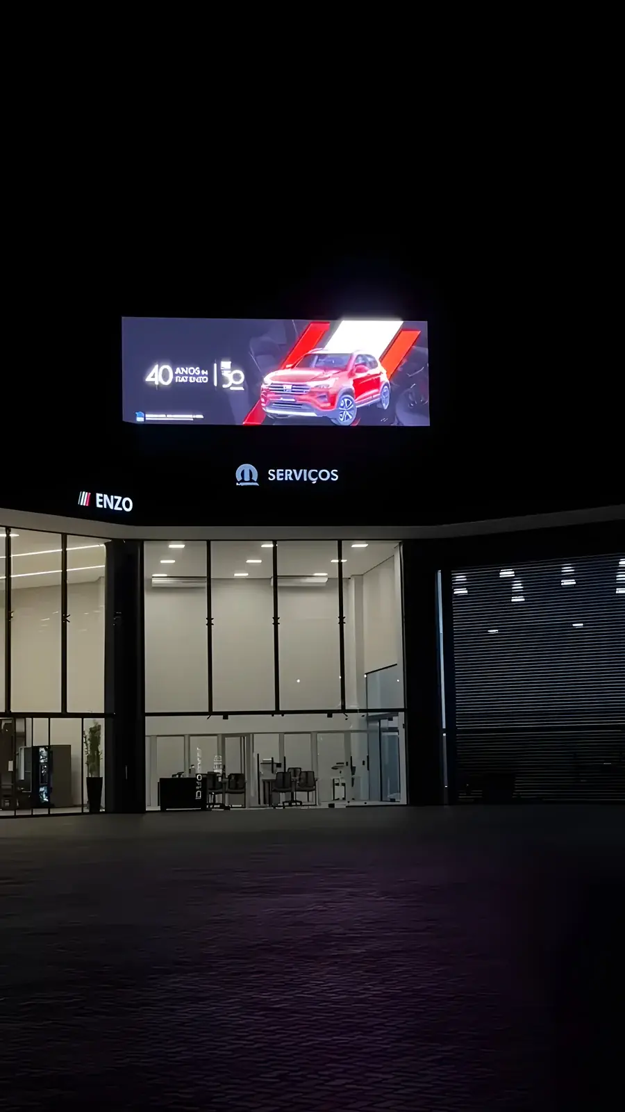 Painel de LED outdoor no topo da concessionária Fiat Campo Grande exibindo campanha à noite