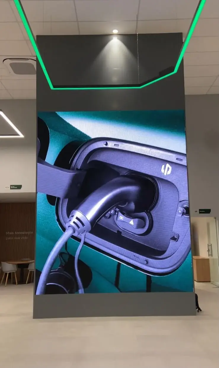 Painel de LED indoor vertical embutido na arquitetura do showroom da Leapmotor, exibindo recarga de veículo elétrico