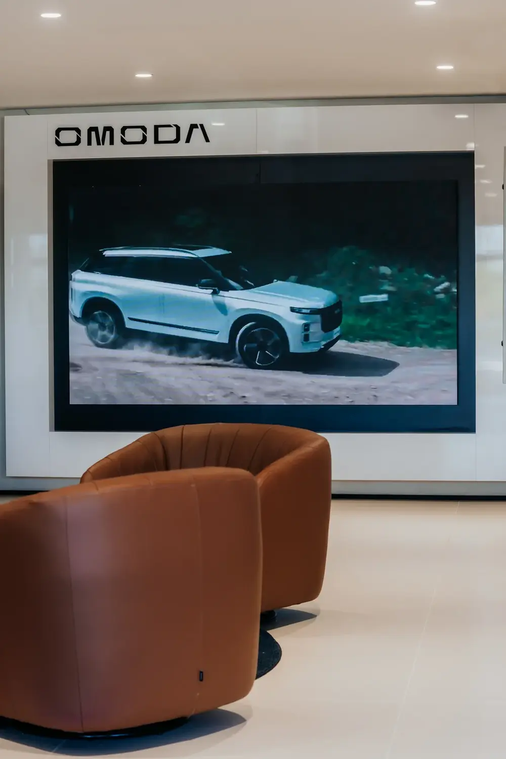 Painel de LED OMODA integrado à parede do showroom, exibindo campanha da marca