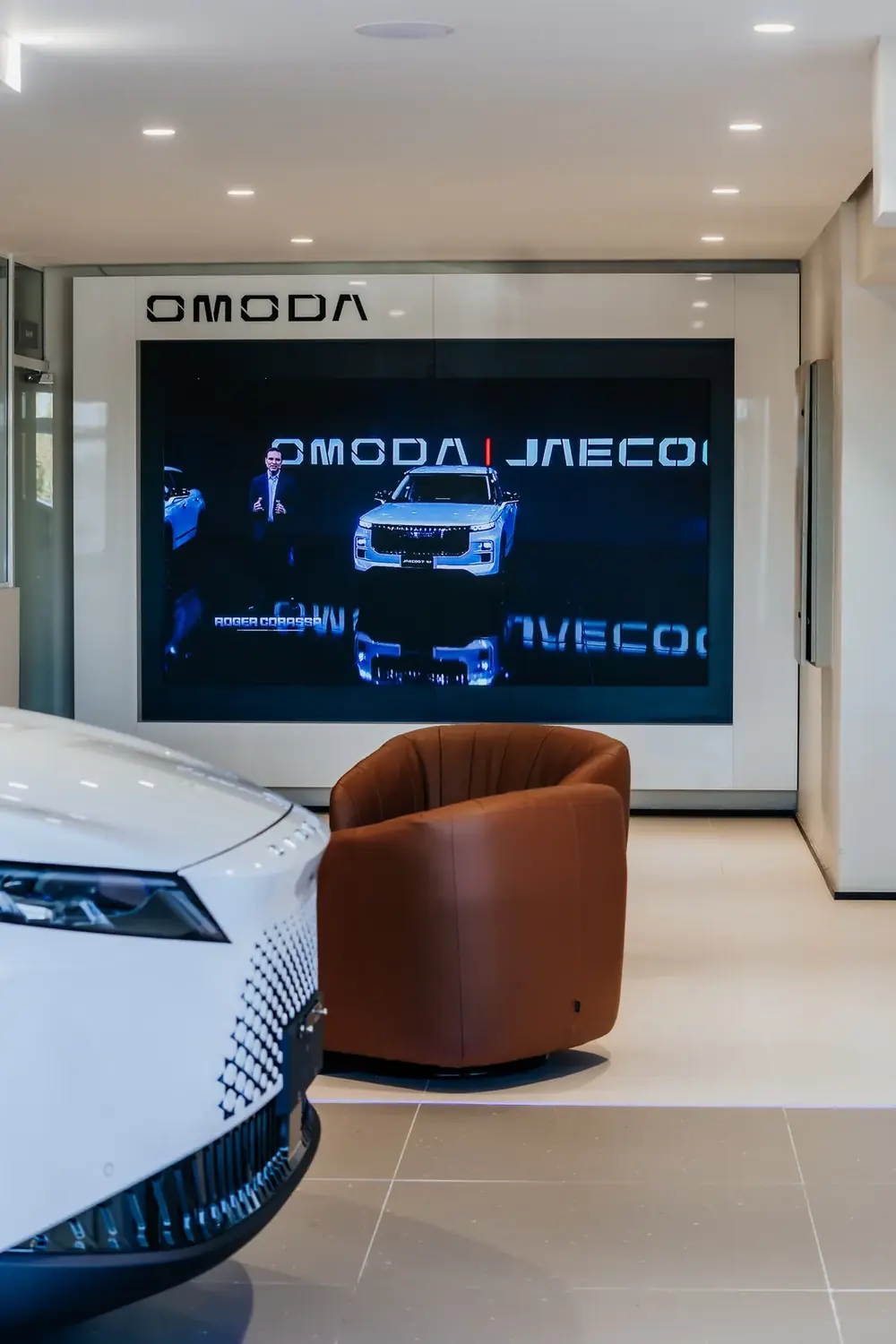 Lounge da concessionária com painel de LED OMODA | JAECOO ao fundo