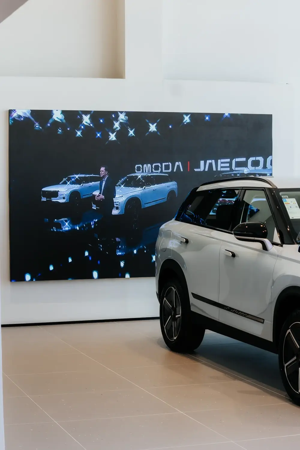 Painel de LED de grande formato OMODA | JAECOO com SUV branco em primeiro plano