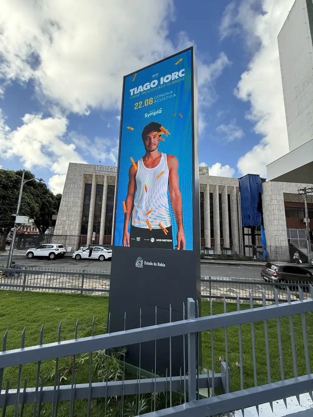 Painel de LED do Teatro Castro Alves visto da rua, com pedestres passando